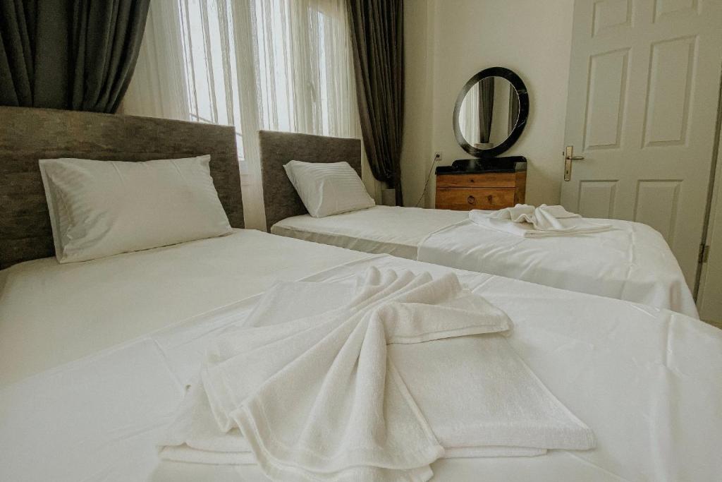 A bed or beds in a room at Begonvil Apart - 1
