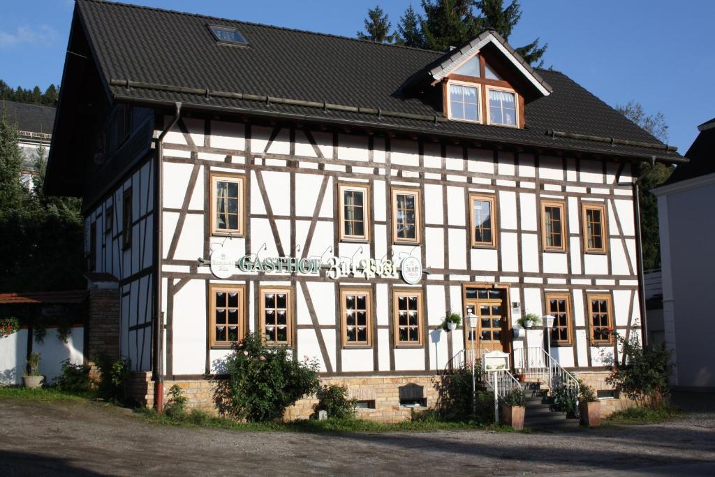 ein weißes und schwarzes Gebäude mit schwarzem Dach in der Unterkunft Gasthof zur Post in Siegen