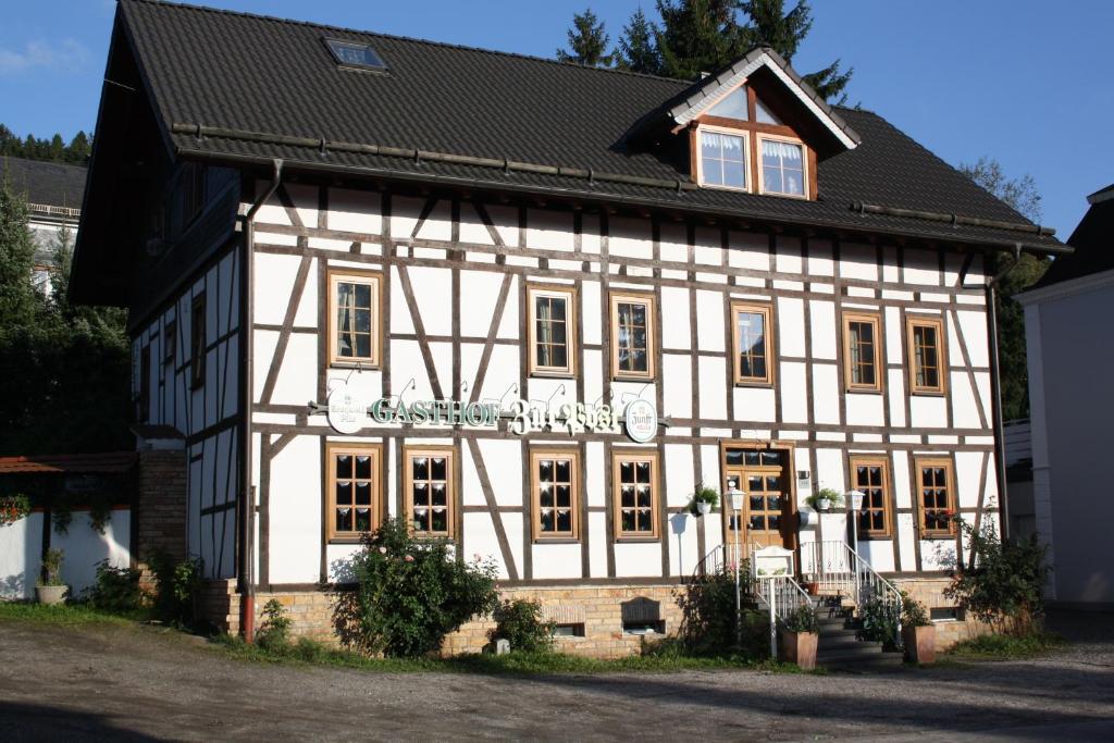 a white and black building with a black roof at Gasthof zur Post in Siegen