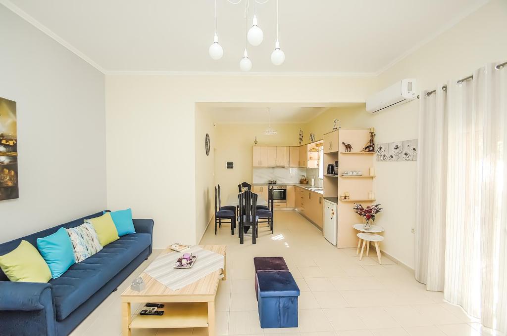 ein Wohnzimmer mit einem blauen Sofa und einem Tisch in der Unterkunft Apartment close to Balos-Elafonisi and Falasarna! in Kámbos
