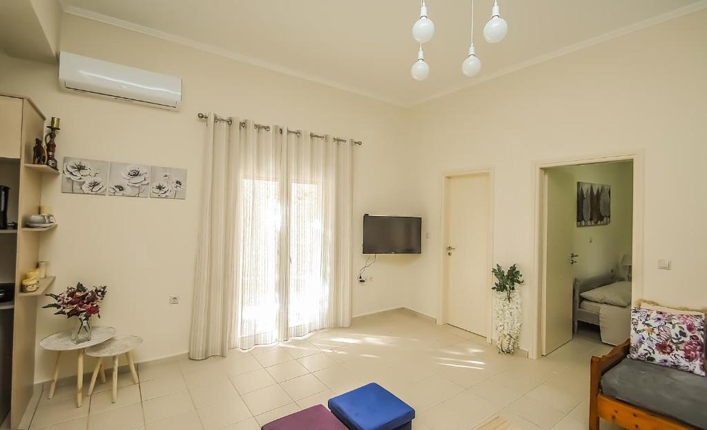 salon z kanapą i telewizorem w obiekcie Apartment close to Balos-Elafonisi and Falasarna! w mieście Kámbos