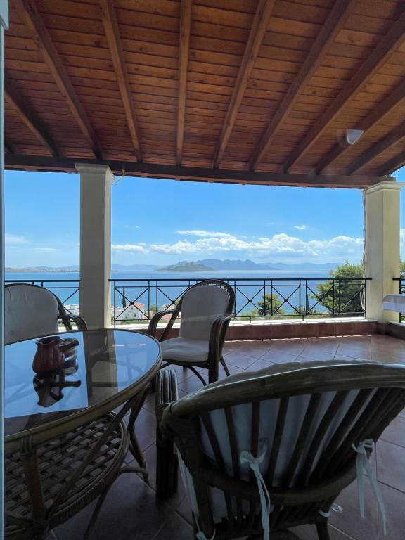 un patio con mesas y sillas y vistas al océano en Amazing view family house! en Kapótidhes