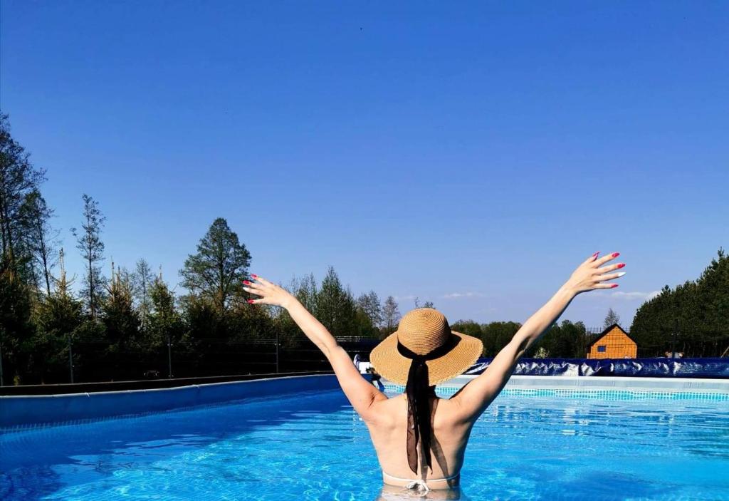 a woman in the water with her arms in the air at Sun House - Domy Mazur in Ełk