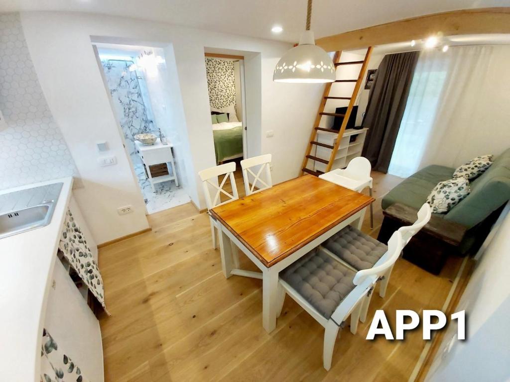 a dining room and living room with a table and chairs at Alpine Village Home in Bohinj