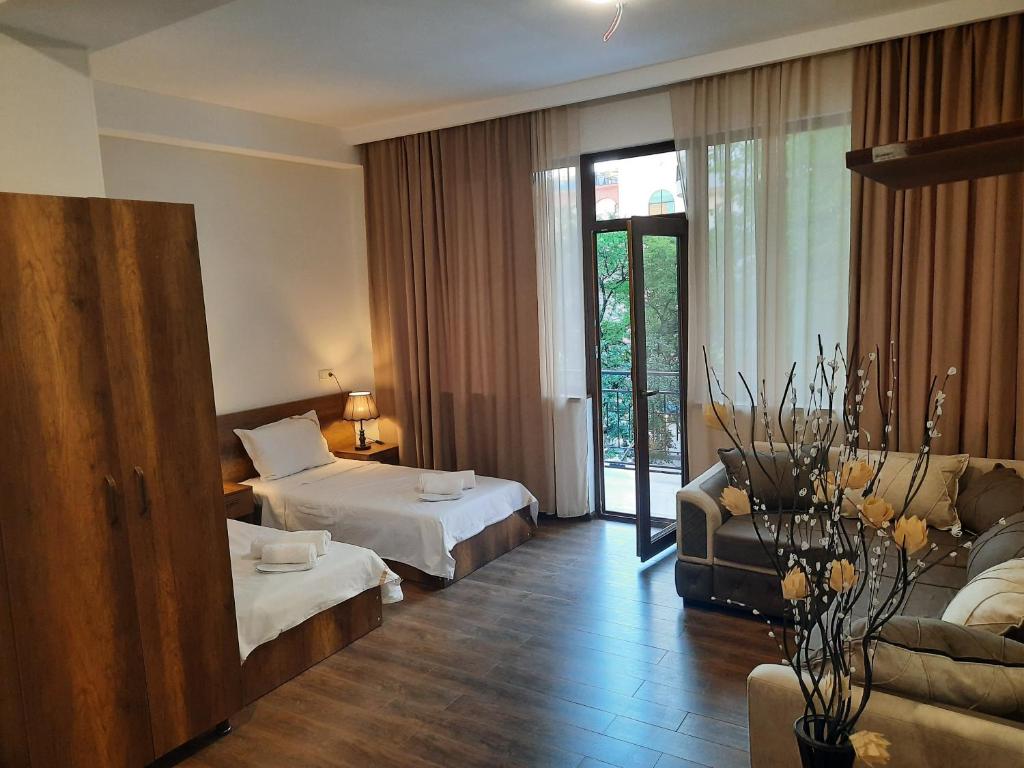 een hotelkamer met 2 bedden en een bank bij Hotel Goldenera in Koetaisi