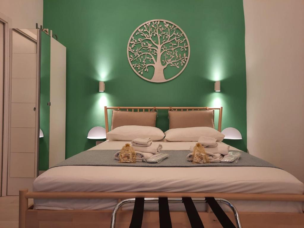 una camera verde con un letto con due gatti sopra di GELSO HOME a Napoli
