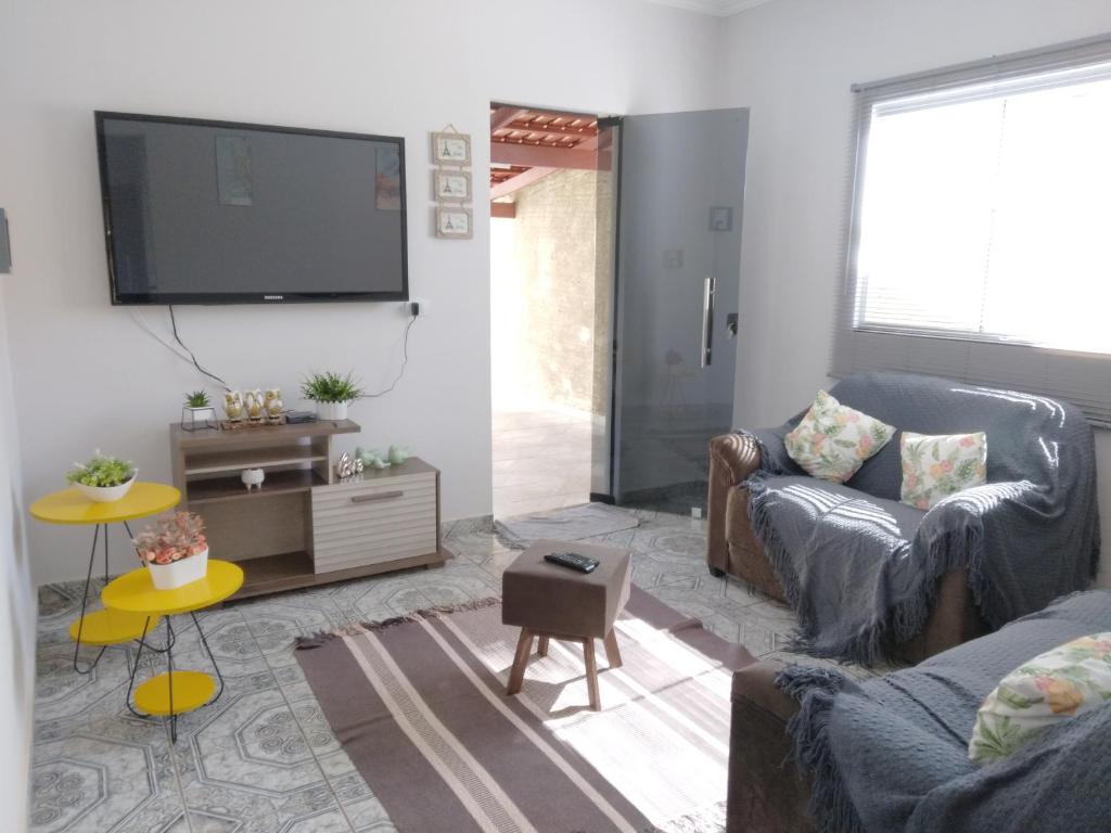 a living room with a couch and a flat screen tv at CASA TEMPORADA - PARA 05 PESSOAS in Trindade