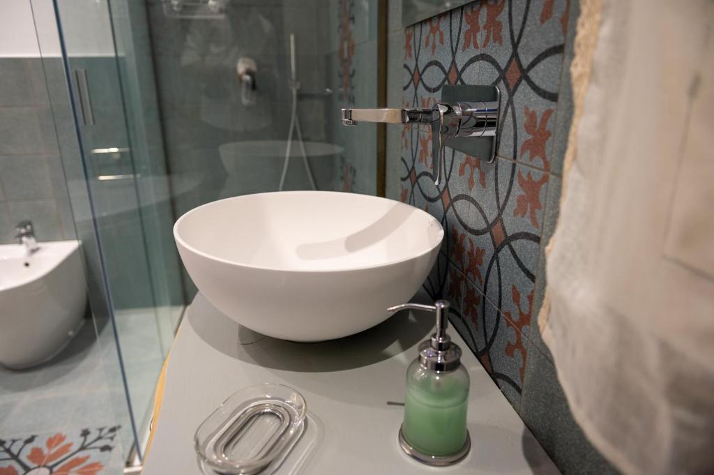a bathroom with a white bowl sink on a counter at Ursino's Luxury in Catania