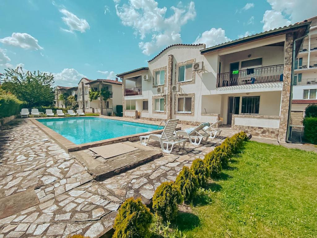 a backyard with a swimming pool and a house at Complex Sea & Sky next to the Beach ! in Kranevo