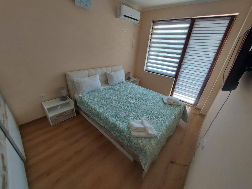 um pequeno quarto com uma cama com duas toalhas brancas em До морето em Burgas