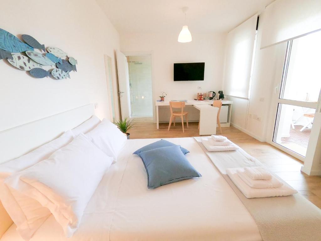 a bedroom with a large white bed and a living room at Suite LightHouse in Cagliari