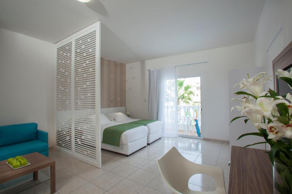 a bedroom with a bed and a couch and a table at Princessa Vera Hotel Apartments in Paphos