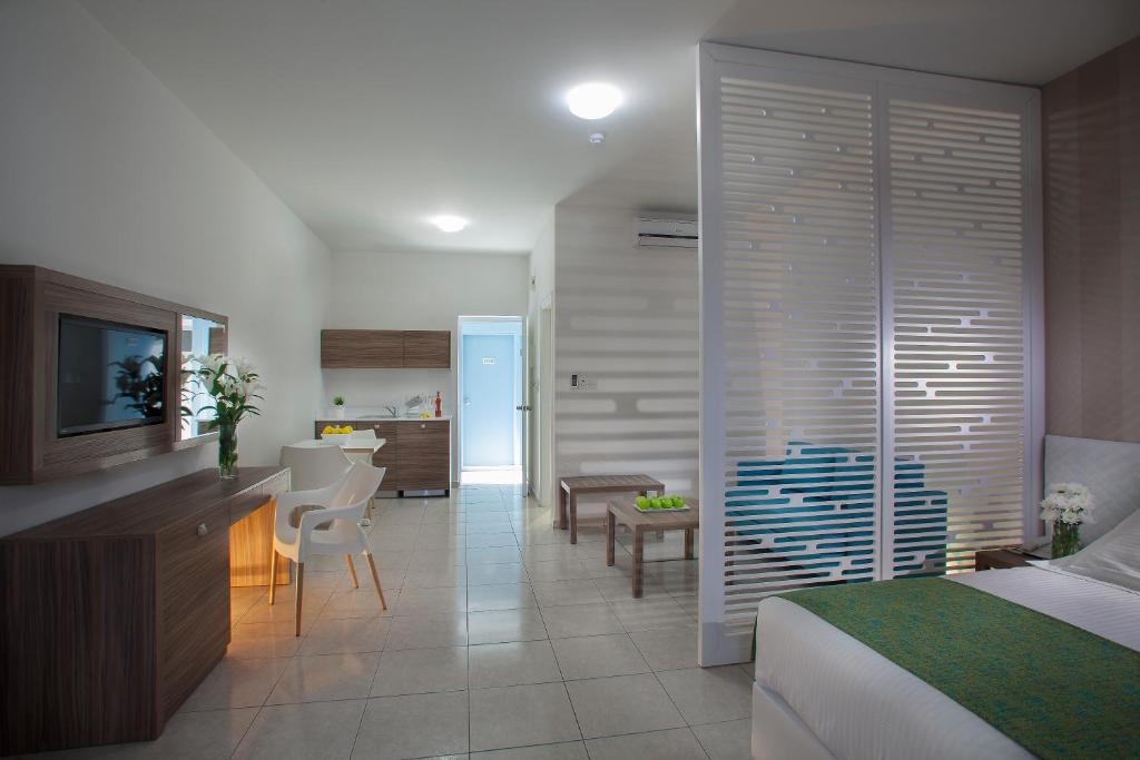 a bedroom with a bed and a kitchen and a dining room at Princessa Vera Hotel Apartments in Paphos