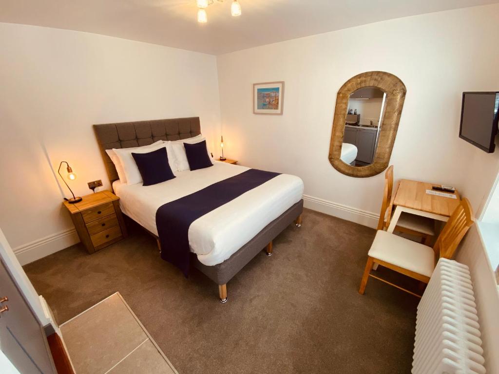 1 dormitorio con 1 cama grande y espejo en Self Contained Guest Suite 1 - Weymouth en Weymouth