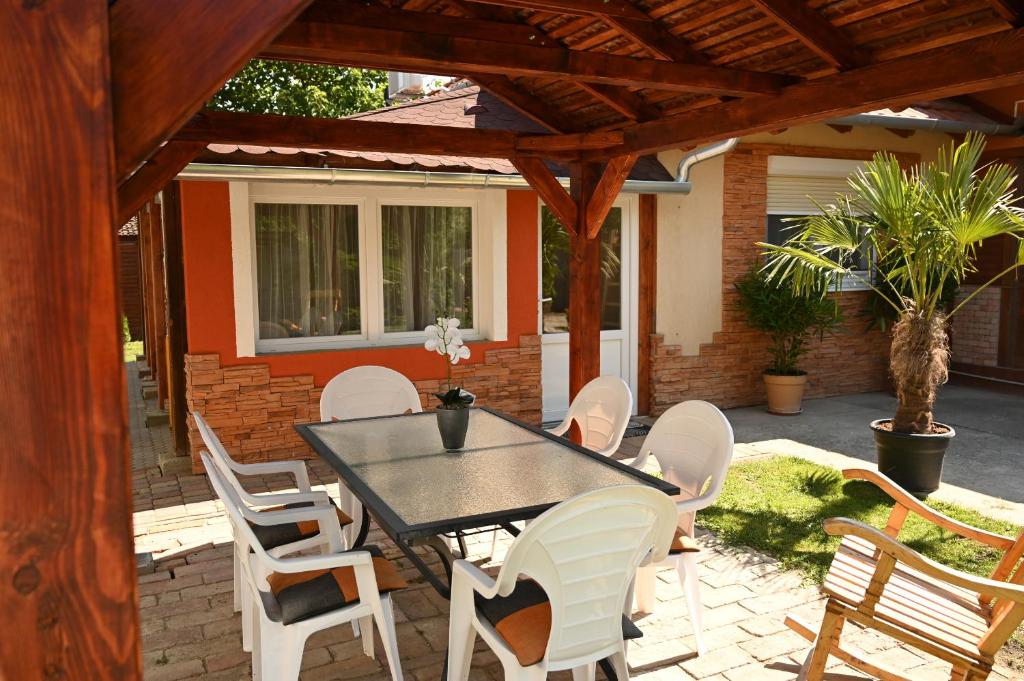 a patio with a black table and white chairs at P&aacute;lma Apartman in Gyula