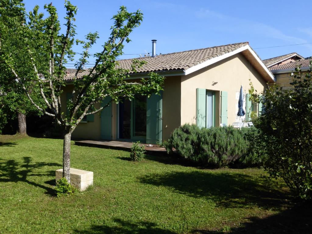 una casa con un árbol en el patio en la petite maison en Espiet