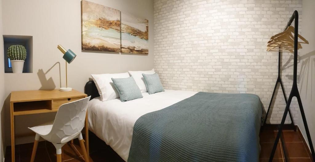 a bedroom with a bed and a brick wall at Vivenda Oliveira - Alojamento Local in Lamego