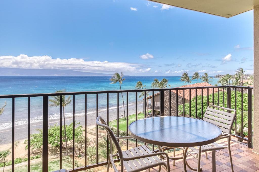 a balcony with a table and chairs and the beach at Kaanapali Shores 706 in Kaanapali