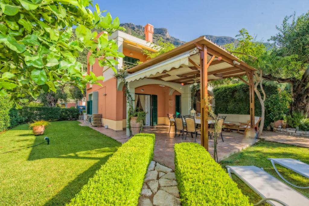 a garden with a pergola and a patio at Wave and Sea Holiday Home in Barbati