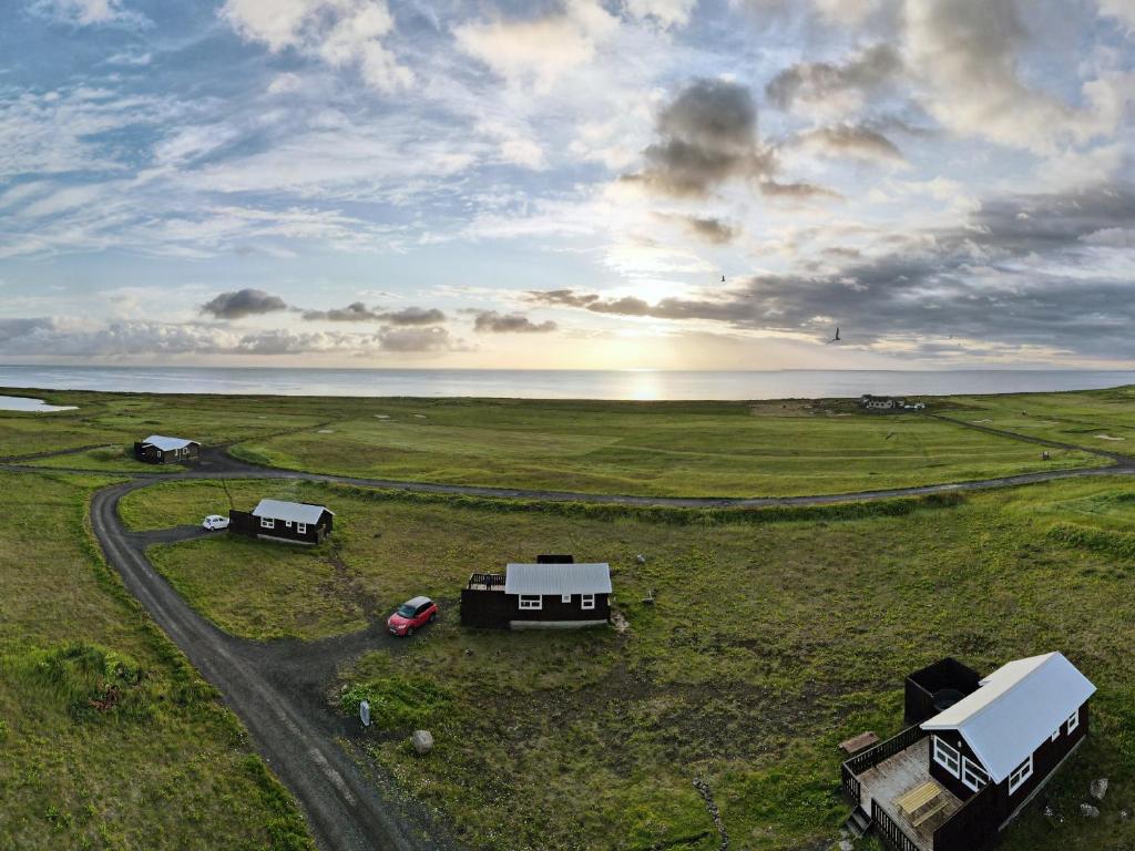 a truck parked on the side of a grassy field at Ocean Break Cabins in Sandgerði