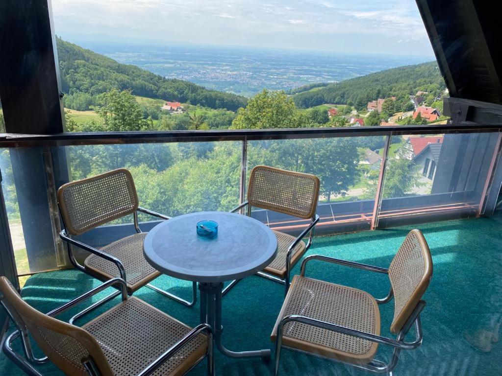 einen Tisch und Stühle auf einem Balkon mit Aussicht in der Unterkunft Overpoint Panorama in Sasbachwalden