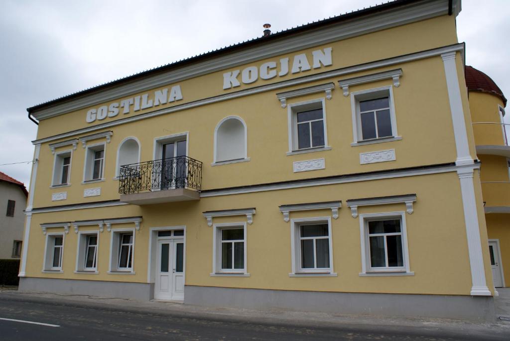un edificio amarillo con un cartel en el costado en Gostilna in prenočišče KOCJAN en Bizeljsko