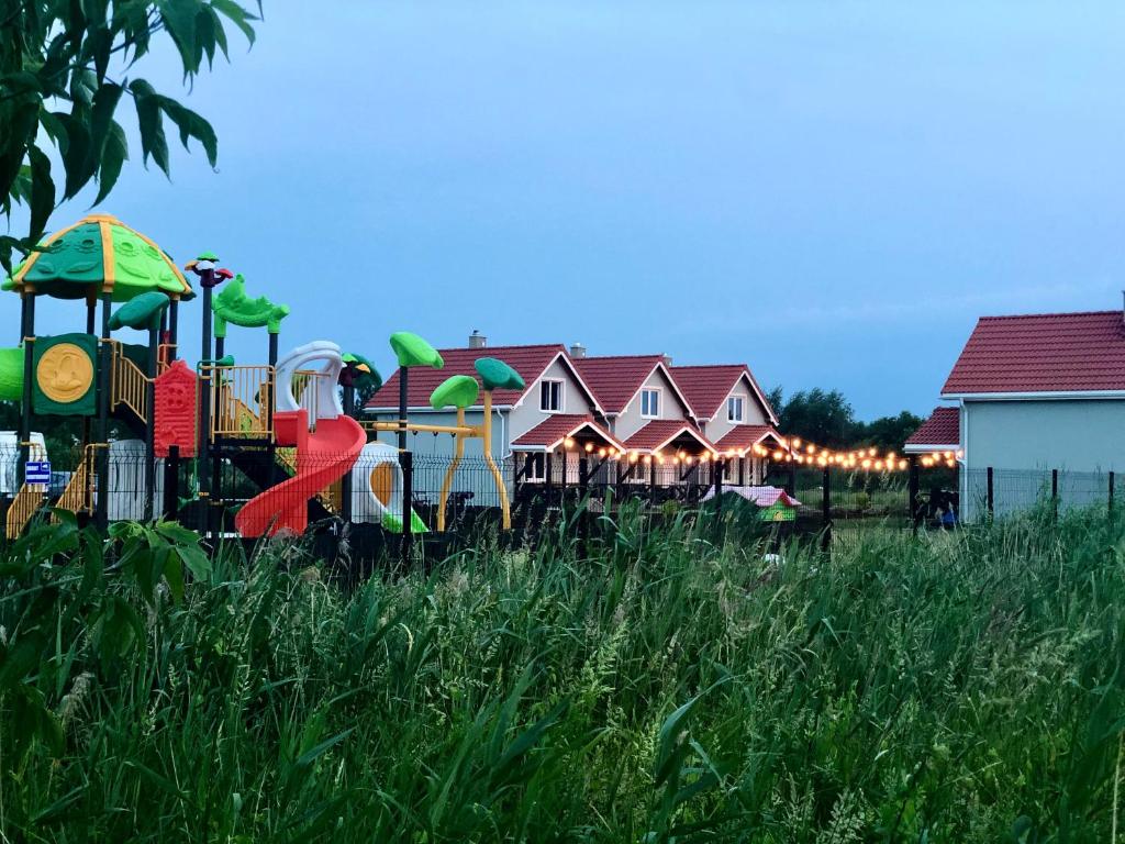 a playground with a train in a field of tall grass at Goose Home and Garden in Łeba