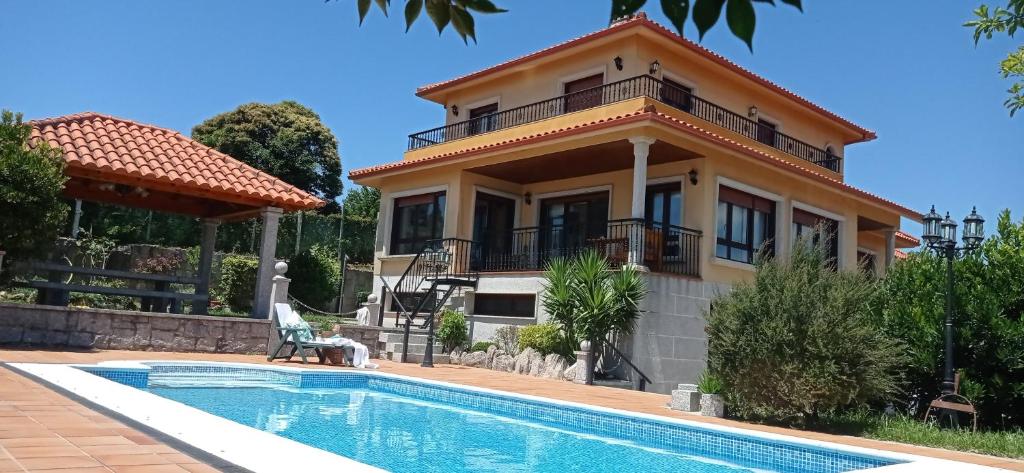 a villa with a swimming pool and a house at Itxi y Jamin - Chalet con vistas a la Ria de Vigo in Moaña