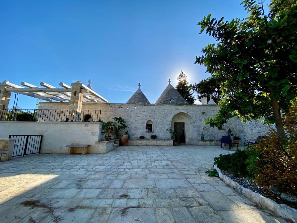 une cour d'une maison avec une terrasse en pierre dans l'établissement I Trulli del Tupparello, à Fasano