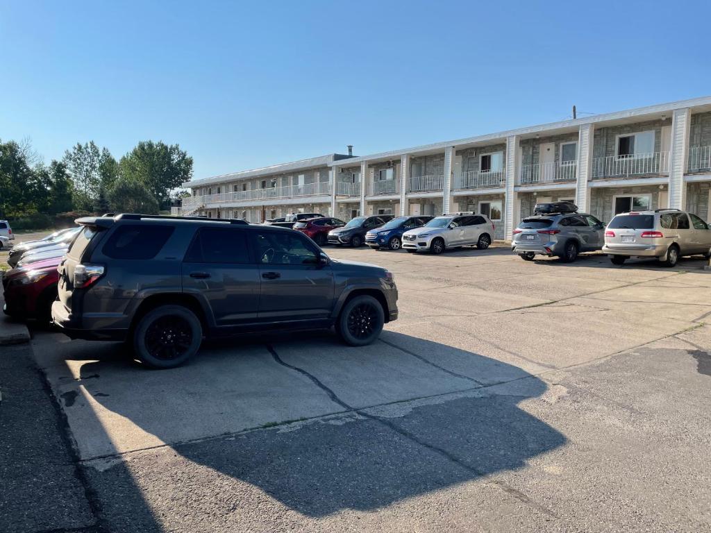 a suv parked in a parking lot in front of a building at Cardston Inn in Cardston