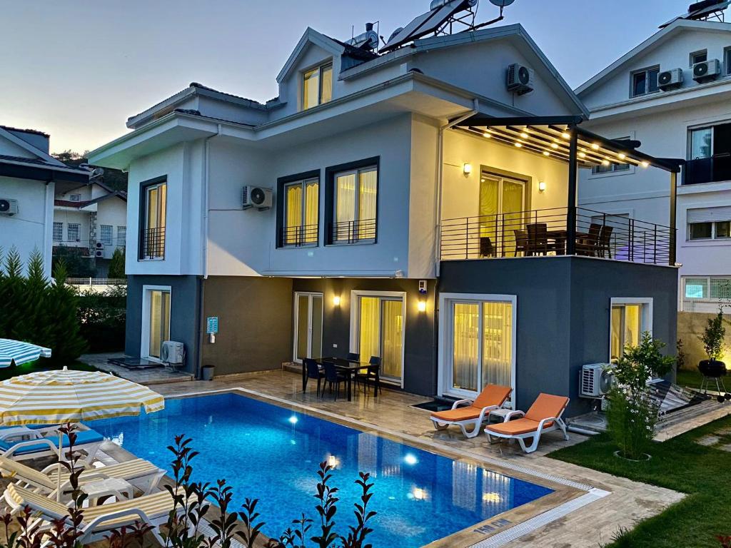 a house with a swimming pool in front of a house at Villasunlight in Fethiye