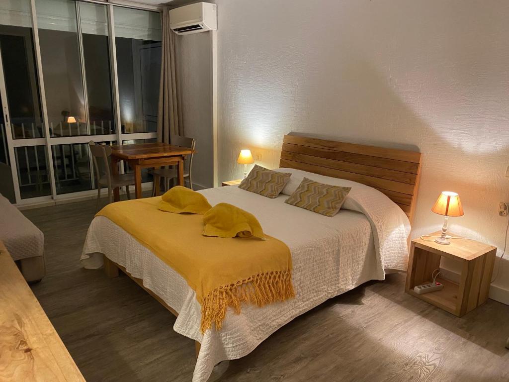 ein Schlafzimmer mit einem Bett mit gelben Decken darauf in der Unterkunft Résidence Savane in Le Gosier