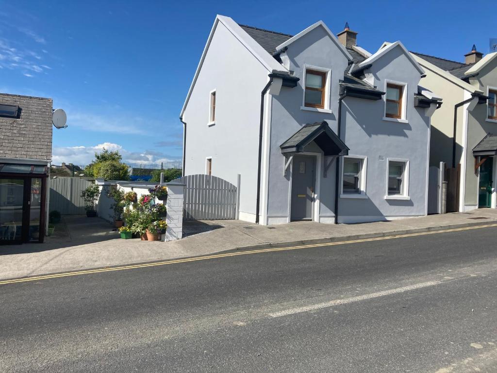 una casa bianca sul lato di una strada di Beautiful Central 3-Bed House in Co Clare a Miltown Malbay