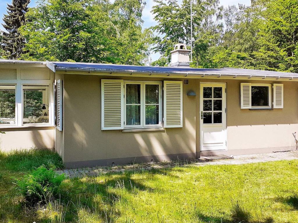 una pequeña casa con un patio de césped en 4 person holiday home in Frederiksv rk, en Frederiksværk