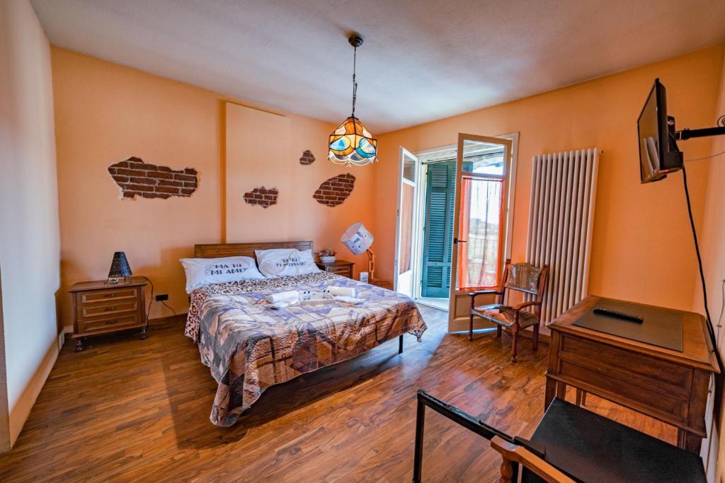 Schlafzimmer mit einem Bett, einem Schreibtisch und einem TV in der Unterkunft Arzigà in Chieri