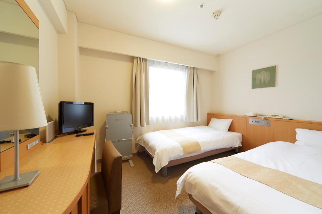Postel nebo postele na pokoji v ubytování Nest Hotel Kumamoto