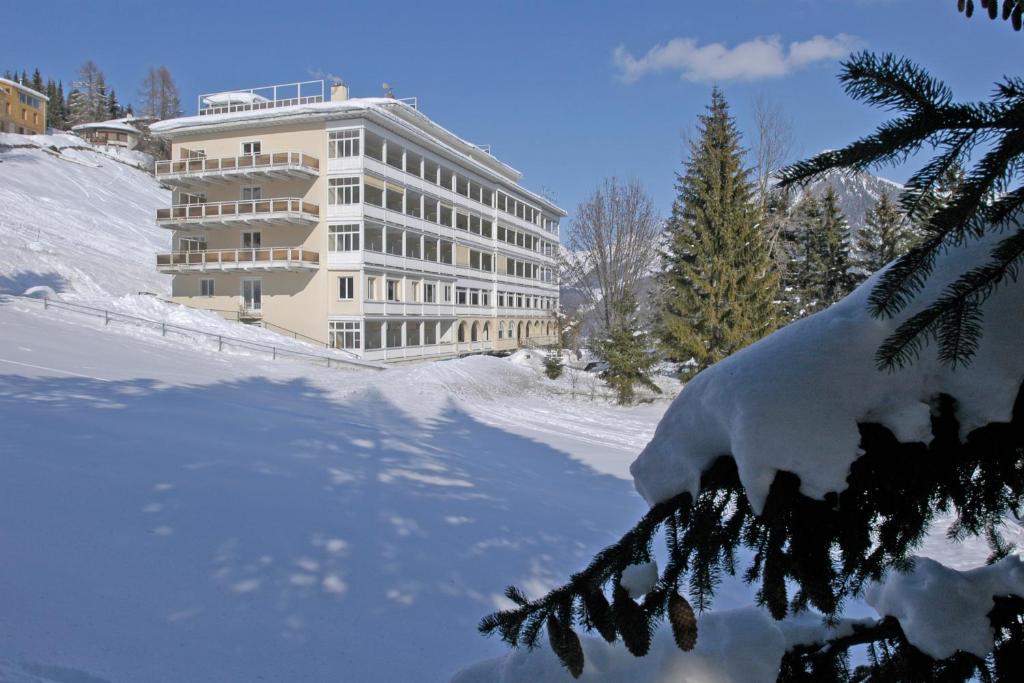 a snow covered building in front of a building at Davos Youth Hostel in Davos