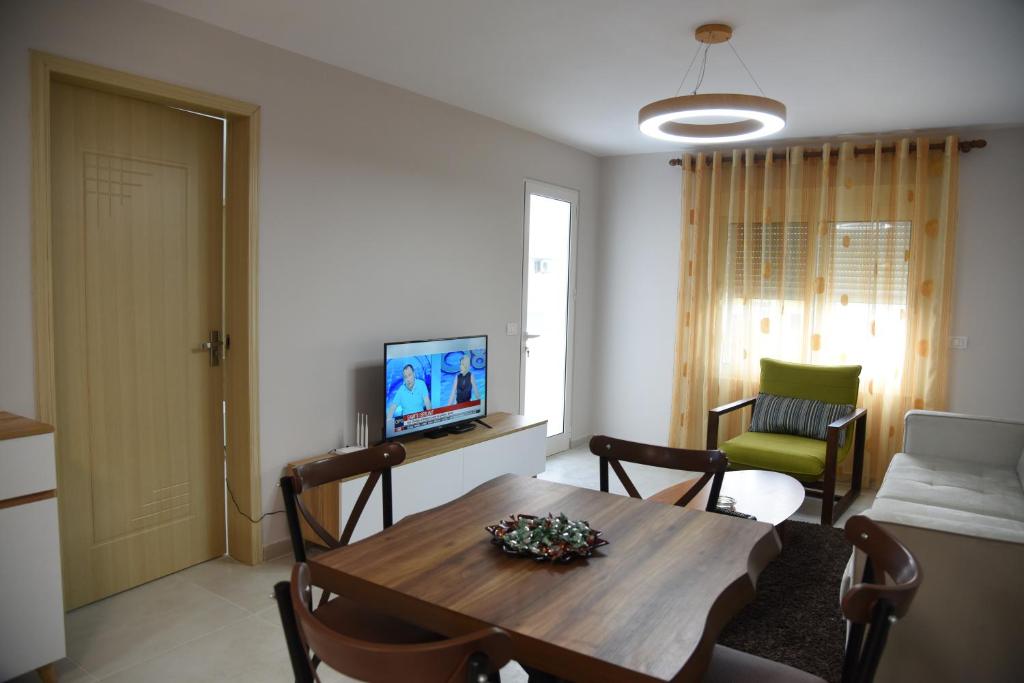 ein Wohnzimmer mit einem Tisch und einem Sofa in der Unterkunft Alex's Apartment in Durrës