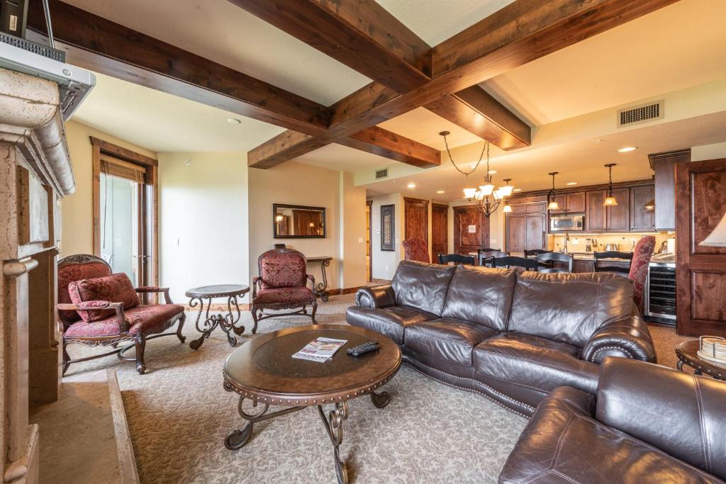 a living room with a leather couch and a table at Luxury Amenities and Resort Ski In Ski Out Pool Hyatt 1 Bedroom in Park City
