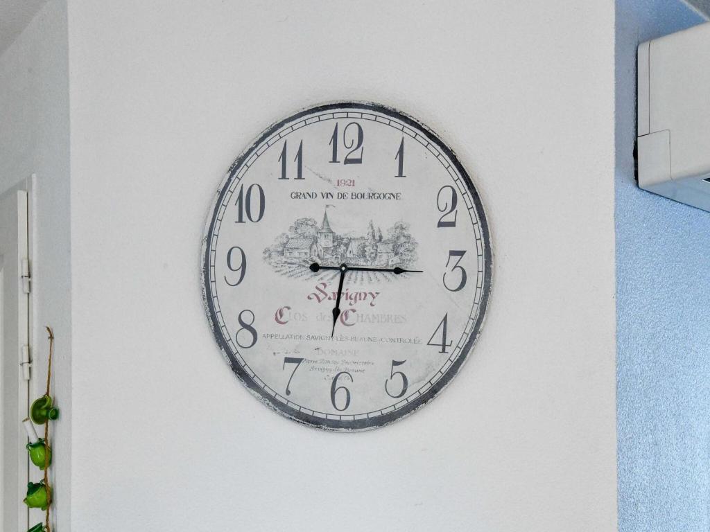 a clock is hanging on a wall at Private bedroom in a guesthouse in Saint Emilion in Saint-Médard-de-Guizières