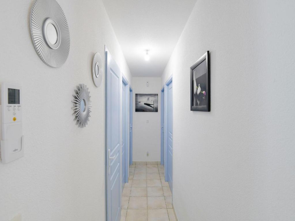 a hallway with blue doors and white walls at Private bedroom in a guesthouse in Saint Emilion in Saint-Médard-de-Guizières