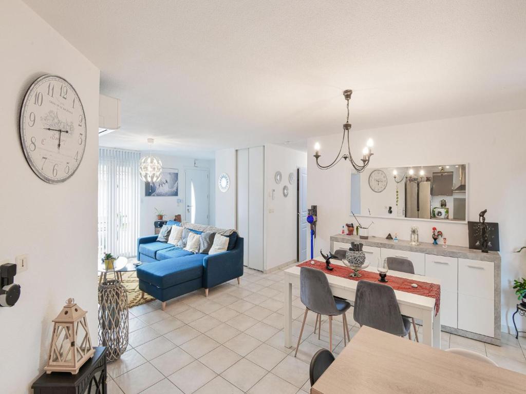 a living room with a blue couch and a kitchen at Private bedroom in a guesthouse in Saint Emilion in Saint-Médard-de-Guizières