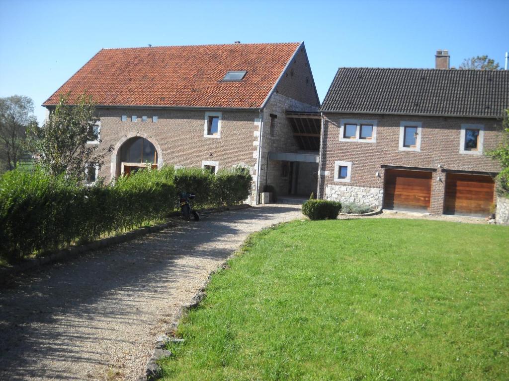 a large brick house with a grass yard at À la Belle Vue in Limbourg