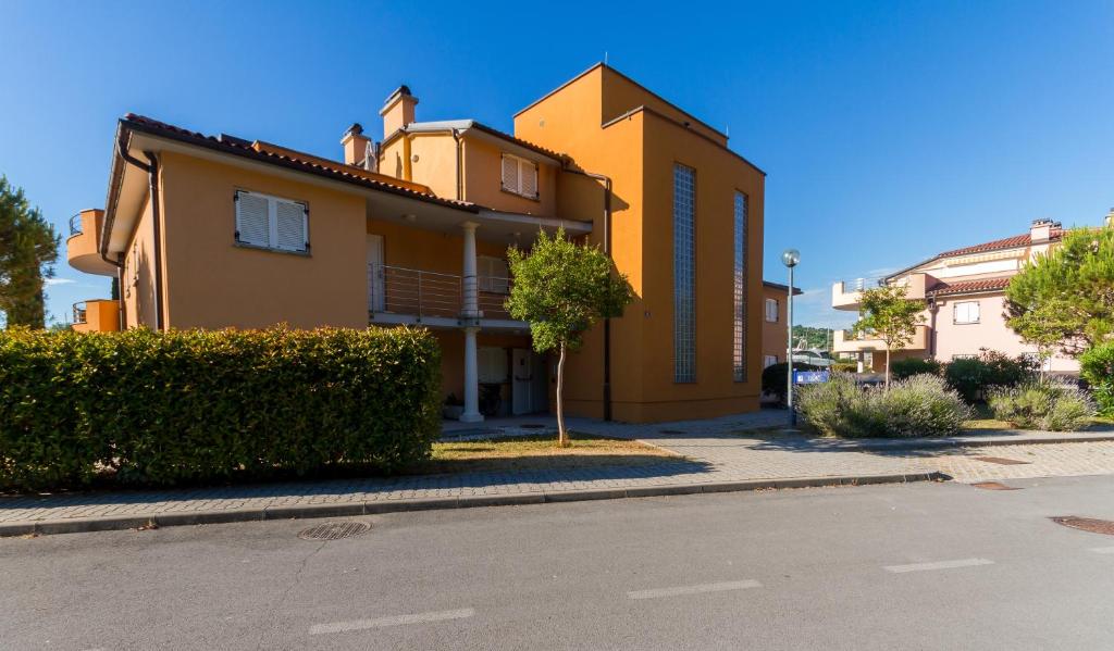 a yellow house on the side of a street at Apartment Residence Marina Portorož LEBIČ 411 in Portorož