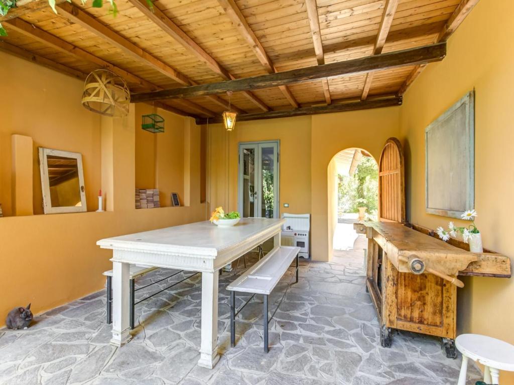 une salle à manger avec une table blanche et un plafond en bois dans l'établissement Belvilla by OYO Villa Lazzarino, à Pise