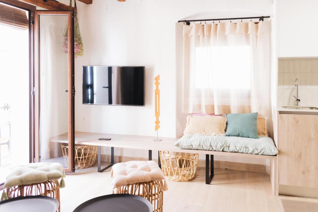 um quarto com um banco com uma mesa e cadeiras em Apartaments la Rambla - Esperó de Bolós - 4 pers em Cornudella