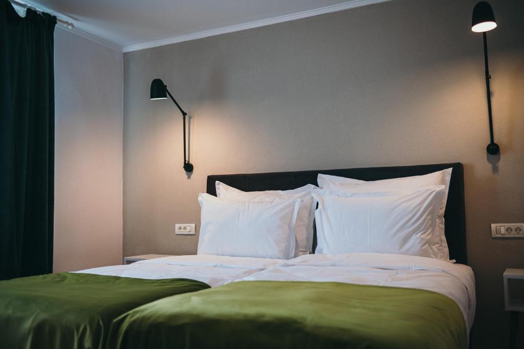 a bedroom with a large bed with white pillows at Nest Guesthouse in Drobeta-Turnu Severin