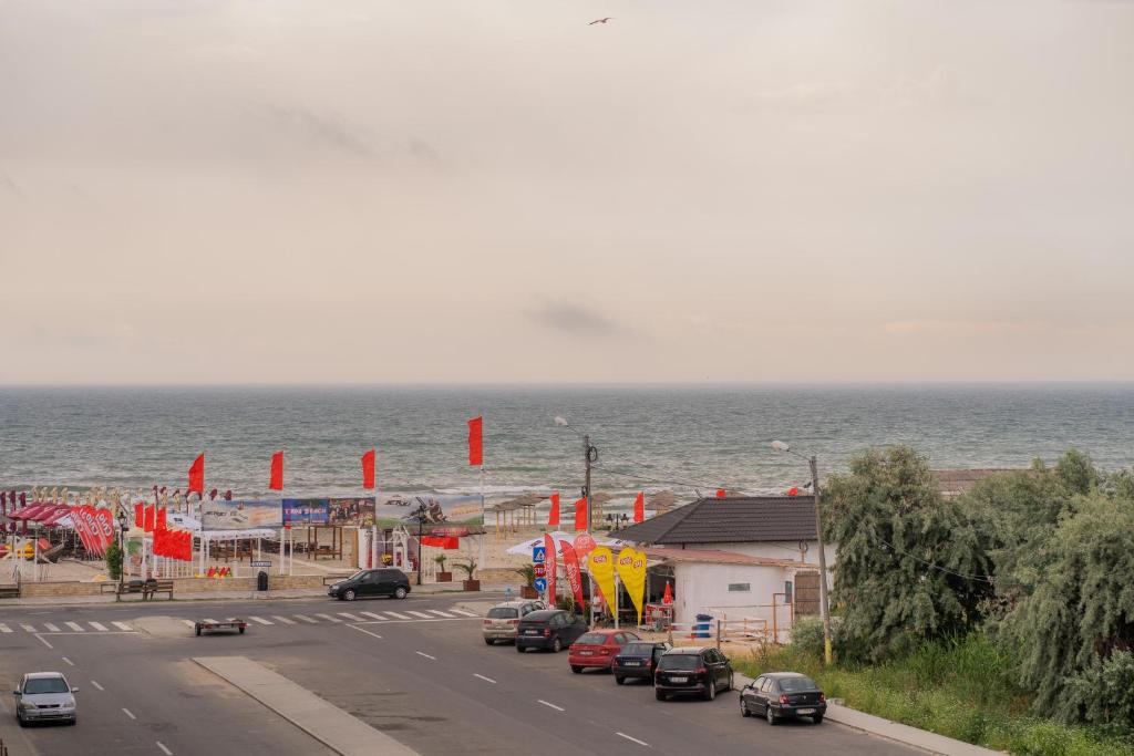 een straat met auto's geparkeerd naast het strand bij HOME FOR SEVEN in Mamaia Nord – Năvodari