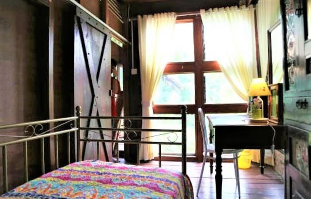 a bedroom with a bed and a desk and a window at NILA HOUSE, Sharia Family Home Stay in Jakarta