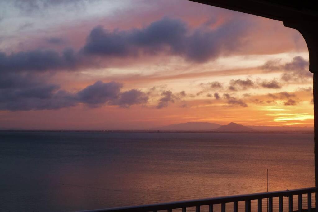 uma vista para o oceano ao pôr-do-sol a partir de uma varanda em Apartamento con vistas inolvidables em San Blas